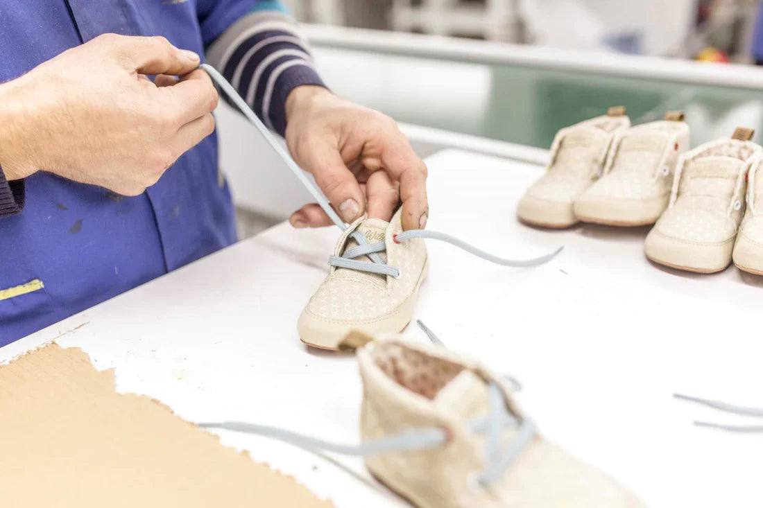 Close-up of two hands threading a lace into a Wildling Shoes minimal shoe.