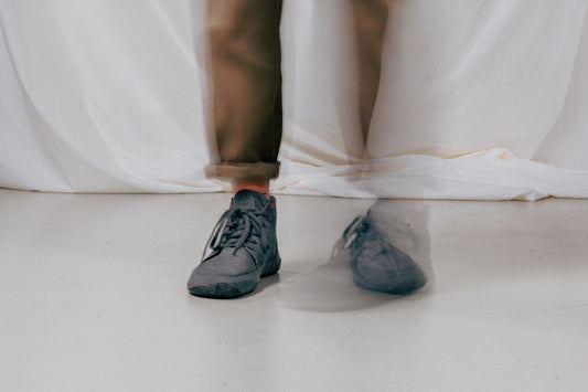 The feet and legs of a person up to the knees in the picture, standing in a very bright interior, on her feet she wears a Wildling Essentials model.
