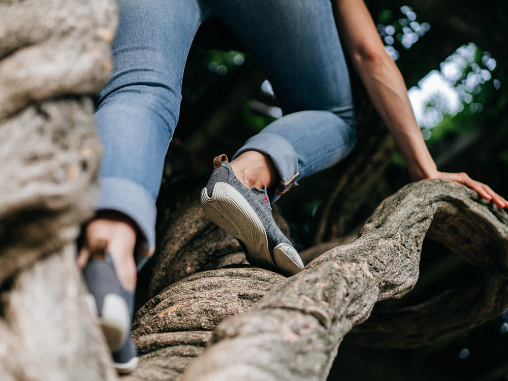 closeup of a person climbing up a tree in wildling shoes